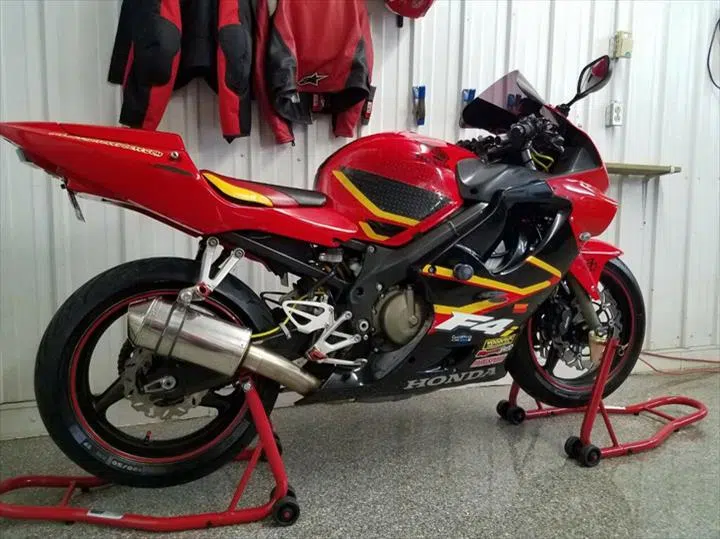 Red Honda sport motorcycle on stands inside a garage — Sharp Image Auto Detail, L.L.C. in Brodhead