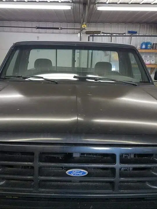 Faded Ford truck hood before restoration inside shop — Sharp Image Auto Detail, L.L.C. in Brodhead