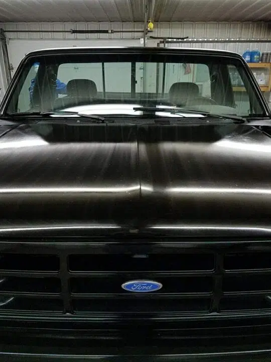 Polished black Ford truck hood reflecting shop lights — Sharp Image Auto Detail, L.L.C. in Brodhead