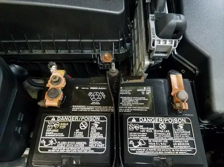 Corroded car battery terminals with warning labels in engine bay — Sharp Image Auto Detail, L.L.C. in Brodhead